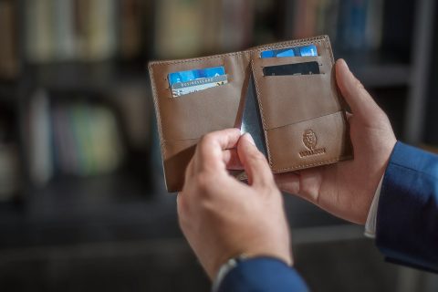 man holding wallet with cards